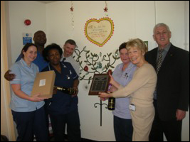 Friend of the Whittington Vivien Trigger presents the Betty Mansell Ward with their plaque.